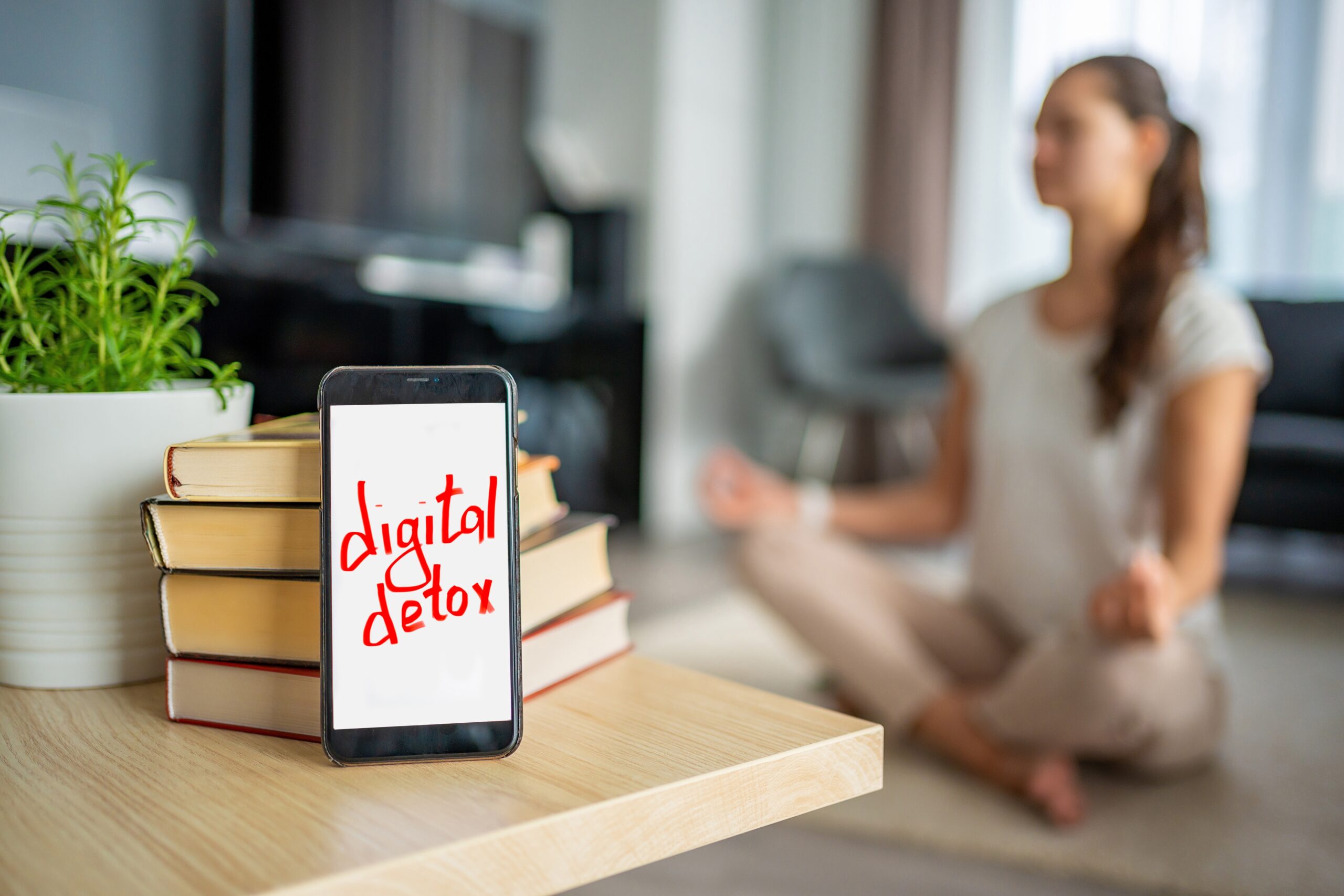 woman sitting on floor meditating while digital detoxing