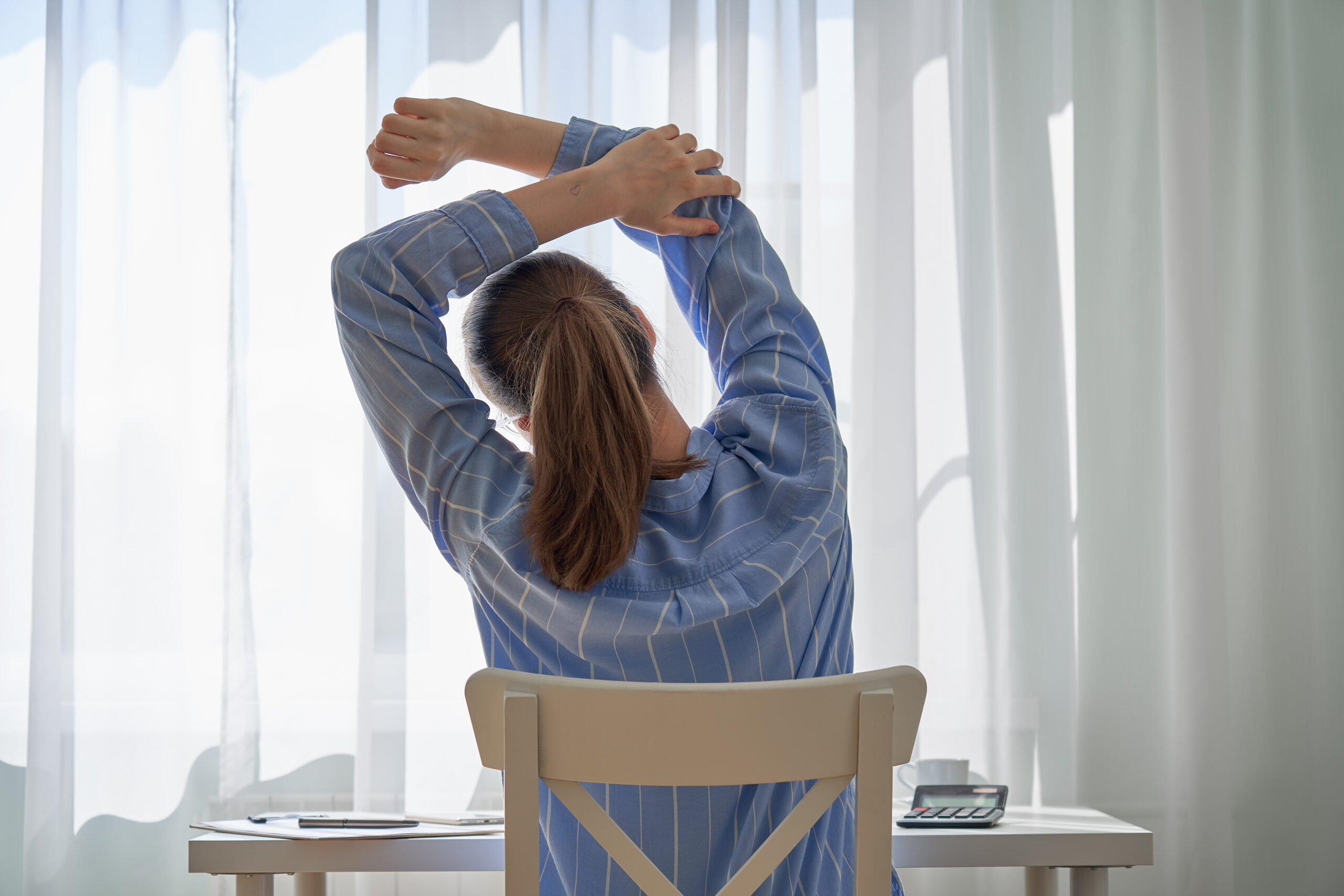 woman sitting on chair stretching